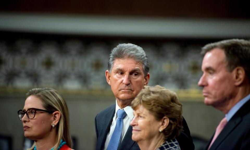 Centrist senators Kyrsten Sinema, left, and Joe Manchin, second from left. Manchin wrote an op-ed calling for a ‘strategic pause’ in advancing the spending package.