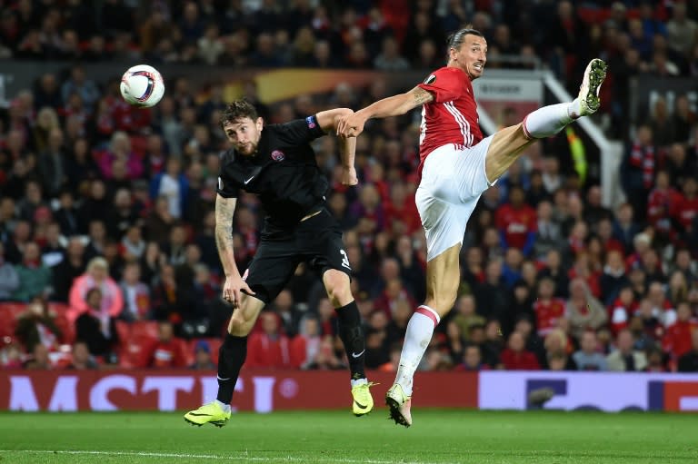 Manchester United's striker Zlatan Ibrahimovic (R) vies in the air with Zorya's Belarusian defender Mikhail Sivakov as he heads the ball towards goal during the UEFA Europa League group A football match between Manchester United and Zorya Luhansk