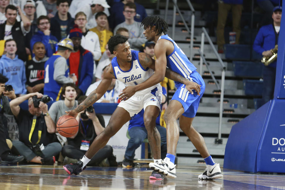 Tulsa forward Martins Igbanu (1) dribbles to the basket against Memphis forward Precious Achiuwa (55) in the first half of an NCAA college basketball game in Tulsa, Okla., Wednesday, Jan. 22, 2020. (AP Photo/Joey Johnson)