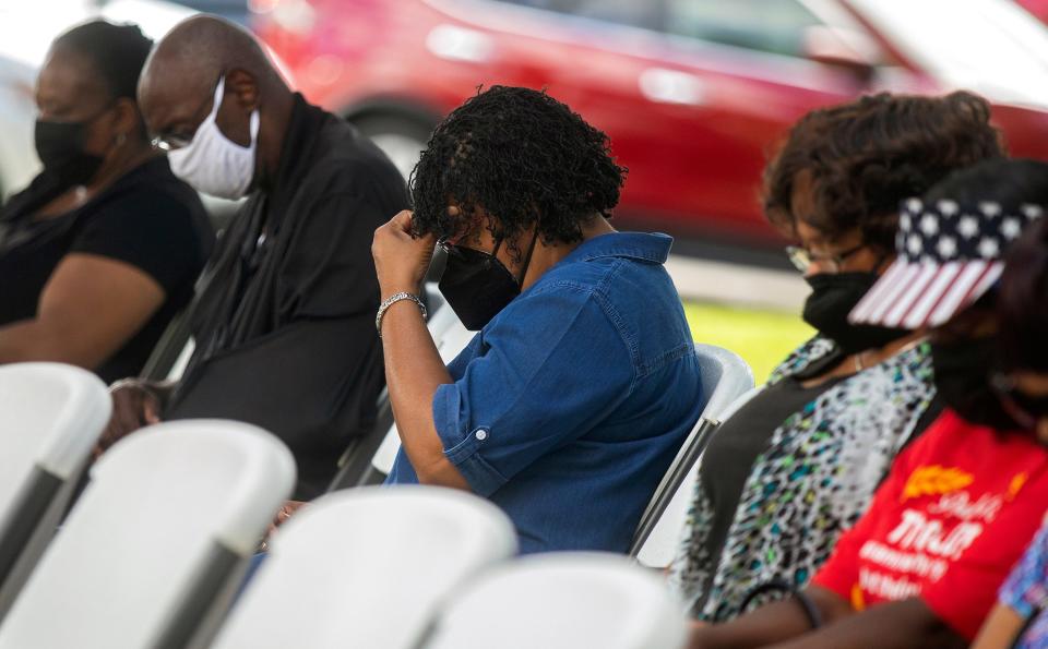Attendees bow their heads in prayer at an event Friday, July 8, 2022 beside the Gadsden County Courthouse in Quincy, Fla. to grieve those affected by the recent fentanyl overdoses.