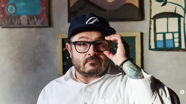 Chef Sean Brock poses with hand on his glasses