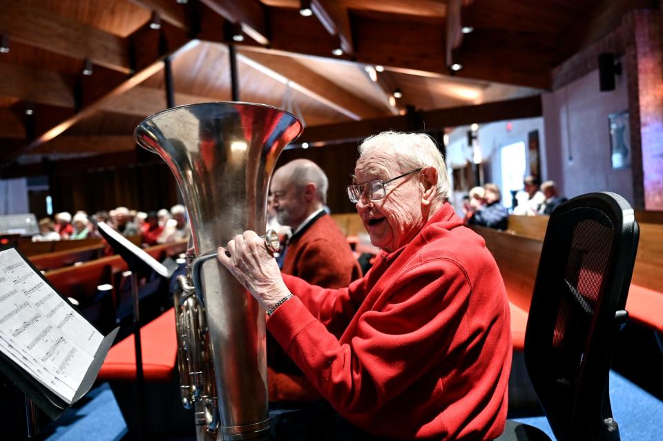 Tuba player Henry Nelson, 100, smiles at the end of his performance with the Asbury Brass Quintet on Wednesday, Dec. 7, 2022, at Ascension Lutheran Church in East Lansing.  Nelson started playing tuba decades ago, stopped for a while and picked it back up for the past 20 years. He has been playing the flute and piccolo for more than 80 years.