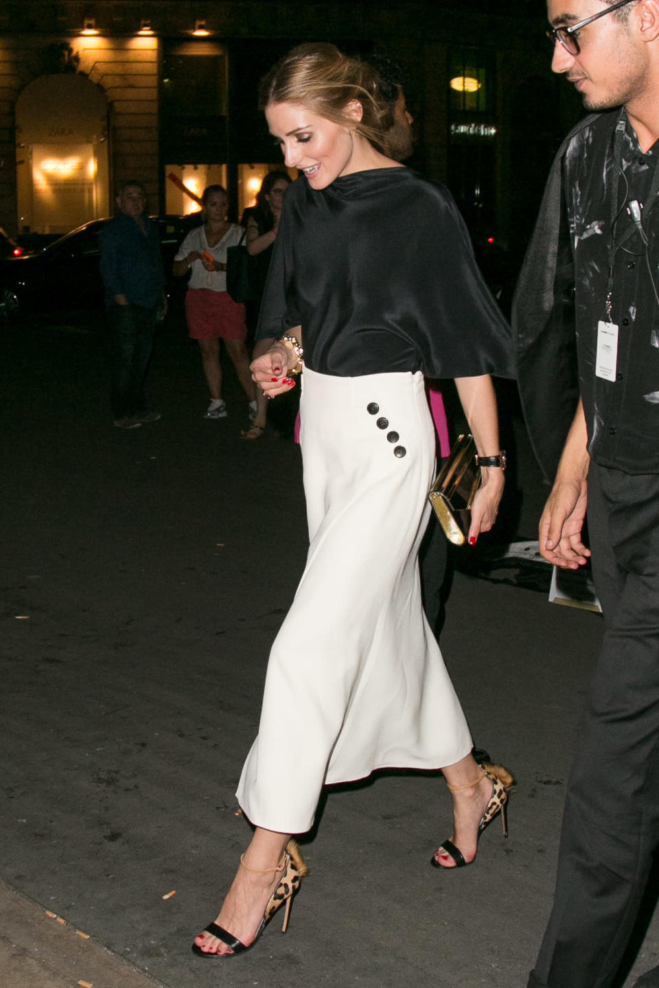 Olivia attends the Giambattista Valli show in Paris wearing a sleek wide leg skirt in white and silky black blouse. This is the perfect look for a day out in Paris. 