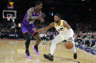 Utah Jazz guard Malik Beasley drives on Phoenix Suns center Deandre Ayton (22) during the first half of an NBA basketball game, Saturday, Nov. 26, 2022, in Phoenix. (AP Photo/Rick Scuteri)