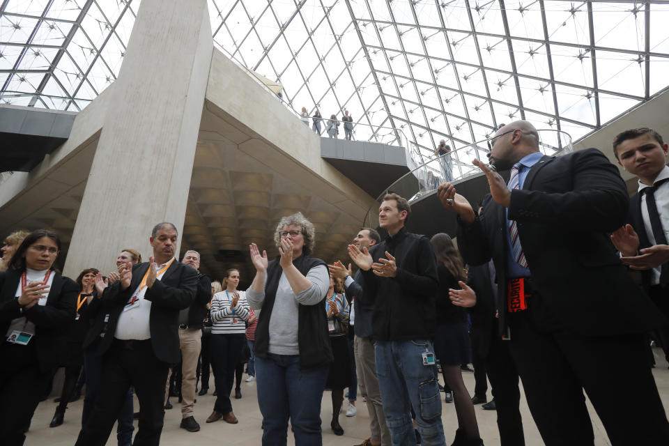 Le Louvre museum employees applaud to pay tribute to the architect of its giant glass pyramid, I.M. Pei, Friday, May 17, 2019 in Paris. Pei died earlier this week at the age of 102. (AP Photo/Michel Euler)