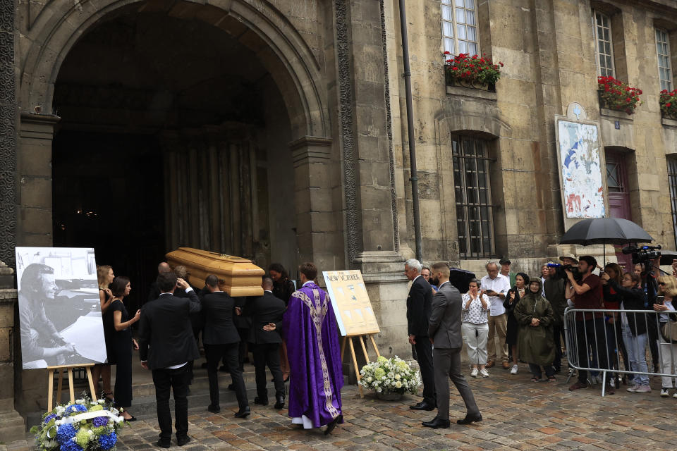 The coffin of Jean-Jacques Sempe is carried inside the Saint-Germain-des-Pres church for his funeral ceremony in Paris, Friday, Aug.19, 2022. Cartoonist Jean-Jacques Sempe, whose simple line drawings captured French life and won international acclaim on the covers of New Yorker magazine, has died on Aug.11, 2022. He was 89. (AP Photo/Aurelien Morissard)