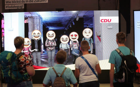 Visitors take part in an interactive emoji display inside the Christian Democratic Union (CDU) walk-in manifesto, located inside a former department store in Berlin - Credit: Krisztian Bocsi/Bloomberg
