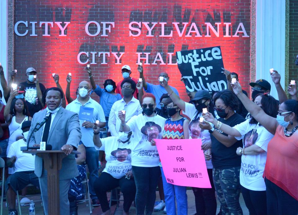 Francys Johnson, a Statesboro civil rights attorney, addresses a crowd of 200 in downtown Sylvania, Georgia on Aug. 14, as members of the Julian Edward Roosevelt Lewis family hoist lit candles in honor of Lewis.