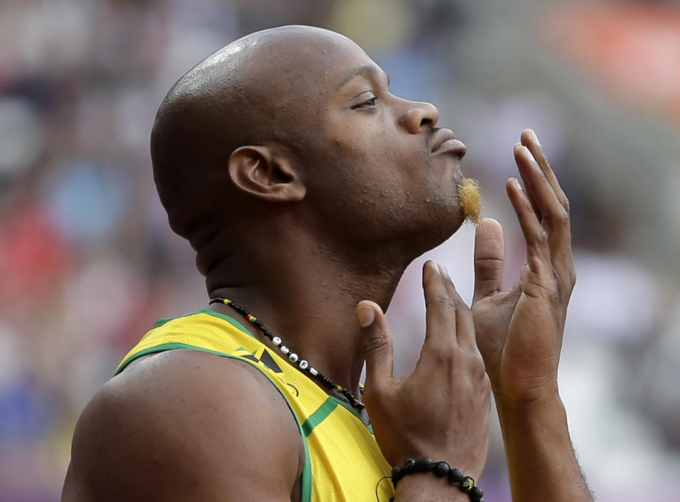 FILE - In this Aug. 4, 2012 file photo, Jamaica's Asafa Powell prepares to compete in a men's 100-meter heat at the 2012 Summer Olympics in London. Powell has been banned from his sport for 18 months. The 31-year-old sprinter tested positive for the banned stimulant oxilofrone at Jamaica's national trials last June. (AP Photo/Matt Slocum, File)