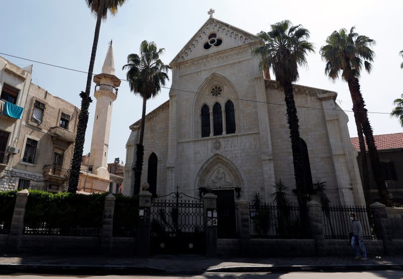 A man with a protective mask walks past a closed church, as all religious gatherings are suspended over concerns of the spread of coronavirus disease (COVID-19) in Damascus