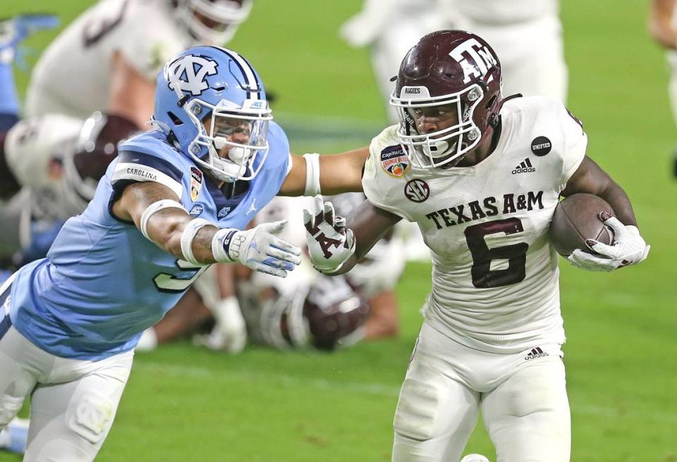 Texas A&M running back Devon Achane (6) runs by North Carolina Tar Heels Cam’Ron Kelly (9) in the fourth quarter in the Capital One 2021 Orange Bowl at Hard Rock Stadium in Miami Gardens, Florida, Saturday, January 2, 2021.