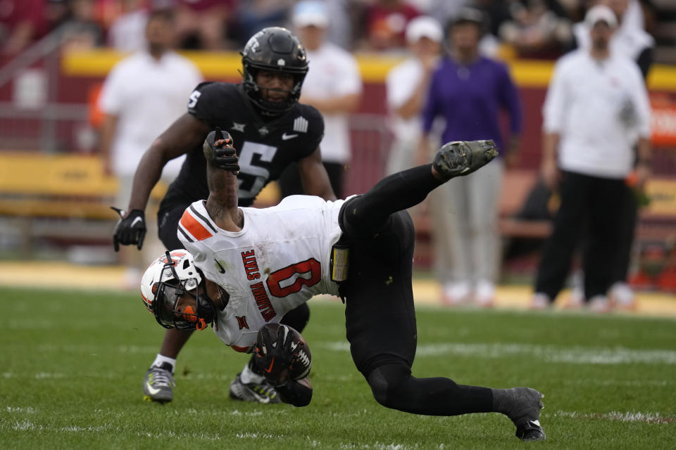 Oklahoma State running back Ollie Gordon II (0) is tripped up on front of Iowa State defensive back Myles Purchase (5) during the first half of an NCAA college football game, Saturday, Sept. 23, 2023, in Ames, Iowa. (AP Photo/Charlie Neibergall)