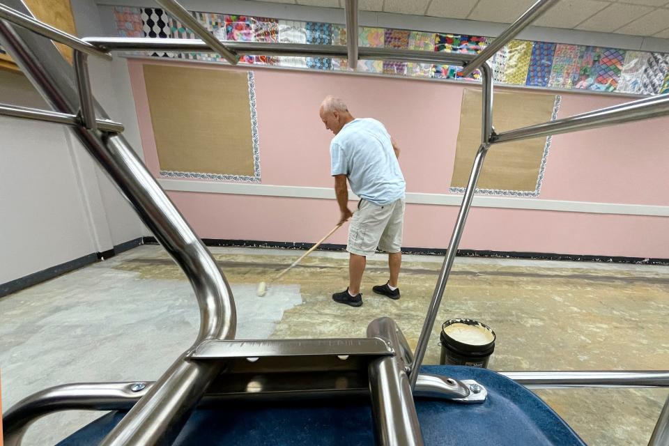 Gary Heapy with The Flooring Authority is framed by the legs of a student desk as he prepares a classroom for recarpeting at Fort Walton Beach High School Tuesday. Students across Okaloosa County will be returning to school on Wednesday, Aug. 10.