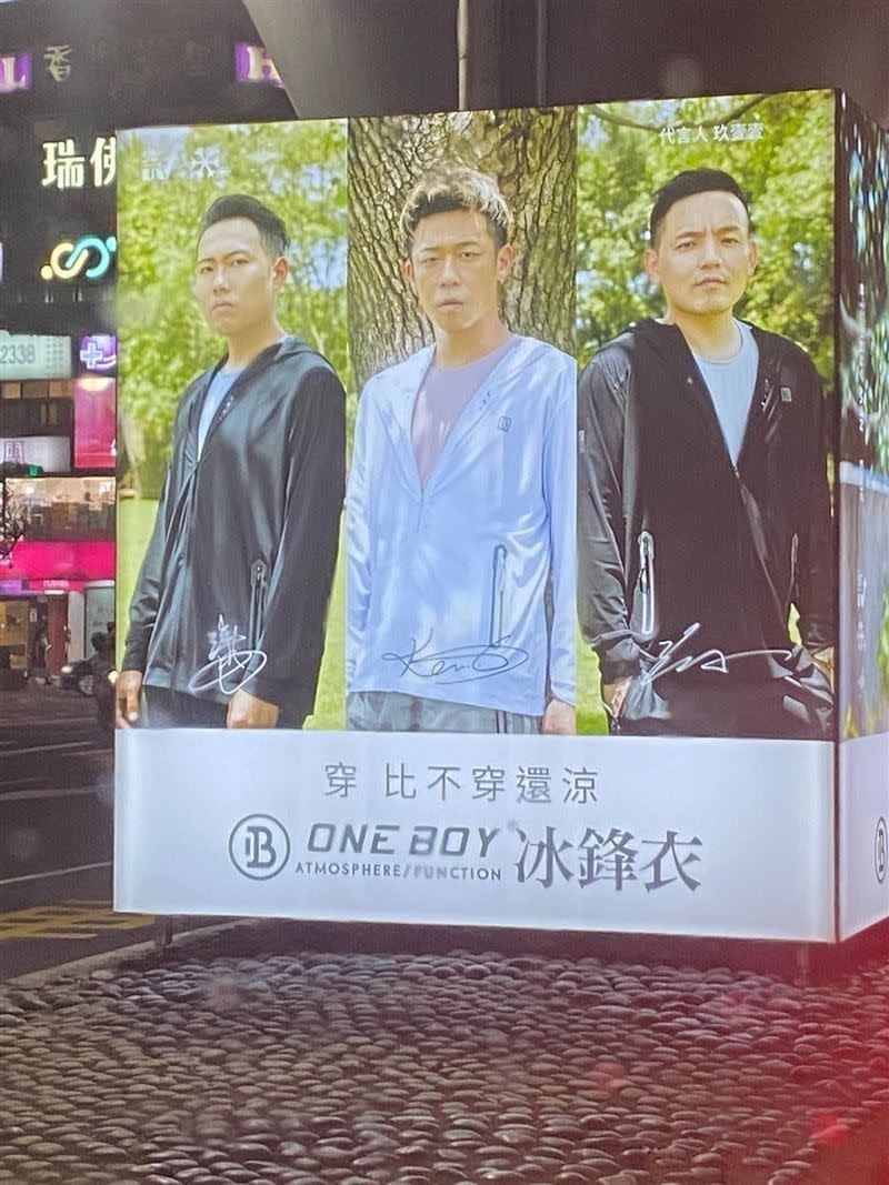 網友看到玖壹壹代言ONE BOY衝鋒衣的廣告燈箱，吃驚：「玖壹壹換團員了？洋蔥呢！」（圖／翻攝自爆廢公社二館）