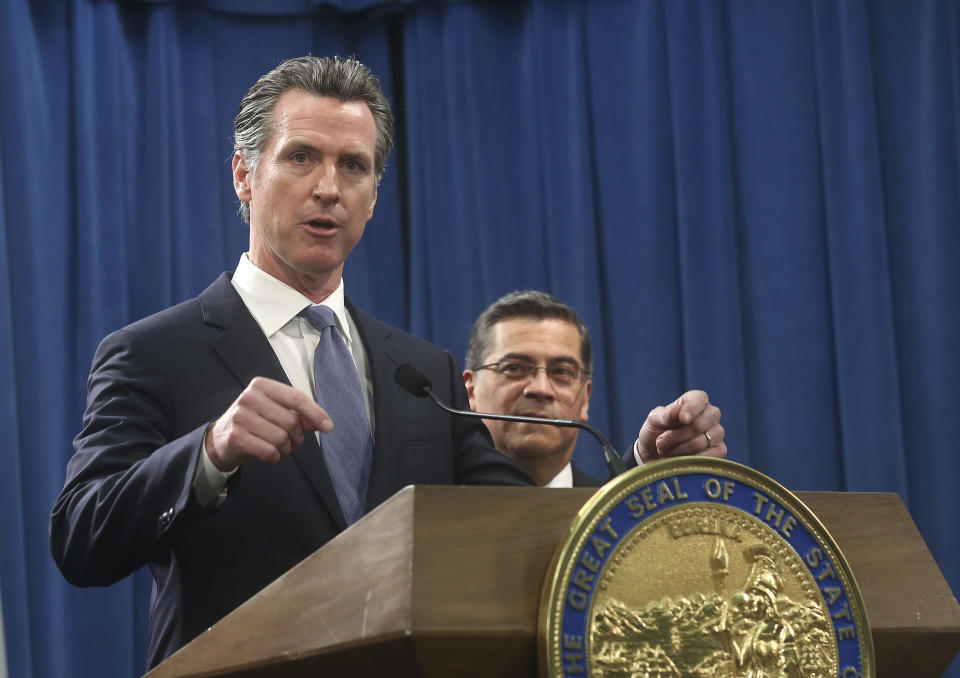 California Gov. Gavin Newsom, left, flanked by Attorney General Xavier Becerra, right, answers a question concerning a probable lawsuit the state will likely file against President Donald Trump over his emergency declaration to fund a wall on the U.S.-Mexico border Friday, Feb. 15, 2019, in Sacramento, Calif. Newsom and Becerra both say there is no emergency at the border and Trump doesn't have the authority to make the declaration. (AP Photo/Rich Pedroncelli)