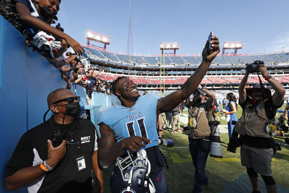 Tennessee Titans wide receiver A.J. Brown (11) takes a picture for a fan as he leaves the field after the Titans beat the Kansas City Chiefs 27-3 in an NFL football game Sunday, Oct. 24, 2021, in Nashville, Tenn. (AP Photo/Wade Payne)