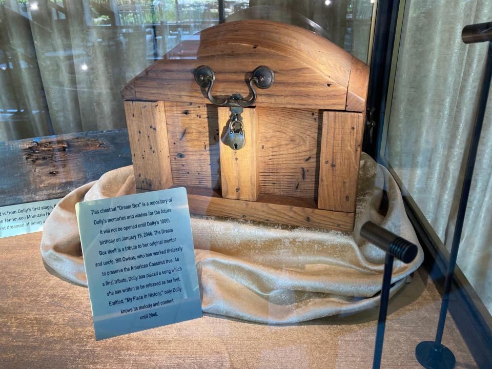 A wooden box containing an unreleased Dolly Parton song displayed at Dollywood in a glass box.