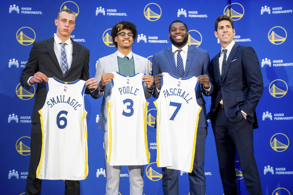 Golden State Warriors NBA basketball general manager Bob Myers, right, stands with draft picks Eric Paschall, Jordan Poole and Alen Smailagic during a media conference on Monday, June 24, 2019, in Oakland, Calif. (AP Photo/Noah Berger)