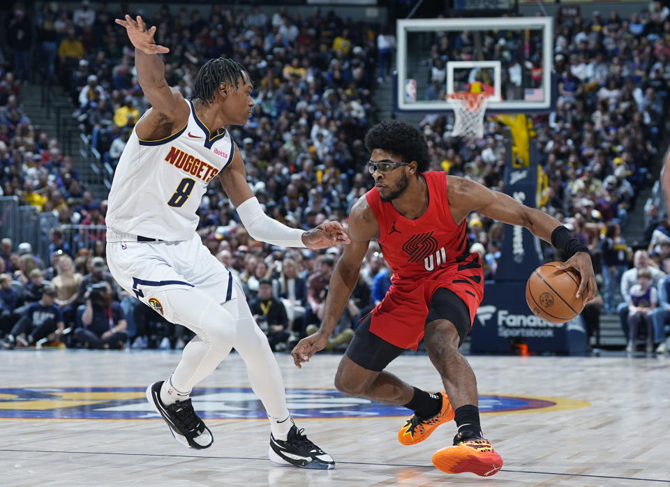 Portland Trail Blazers guard Scoot Henderson, right, looks to drive the lane as Denver Nuggets forward Peyton Watson, left, defends in the first half of an NBA basketball game Sunday, Feb. 4, 2024, in Denver. (AP Photo/David Zalubowski)