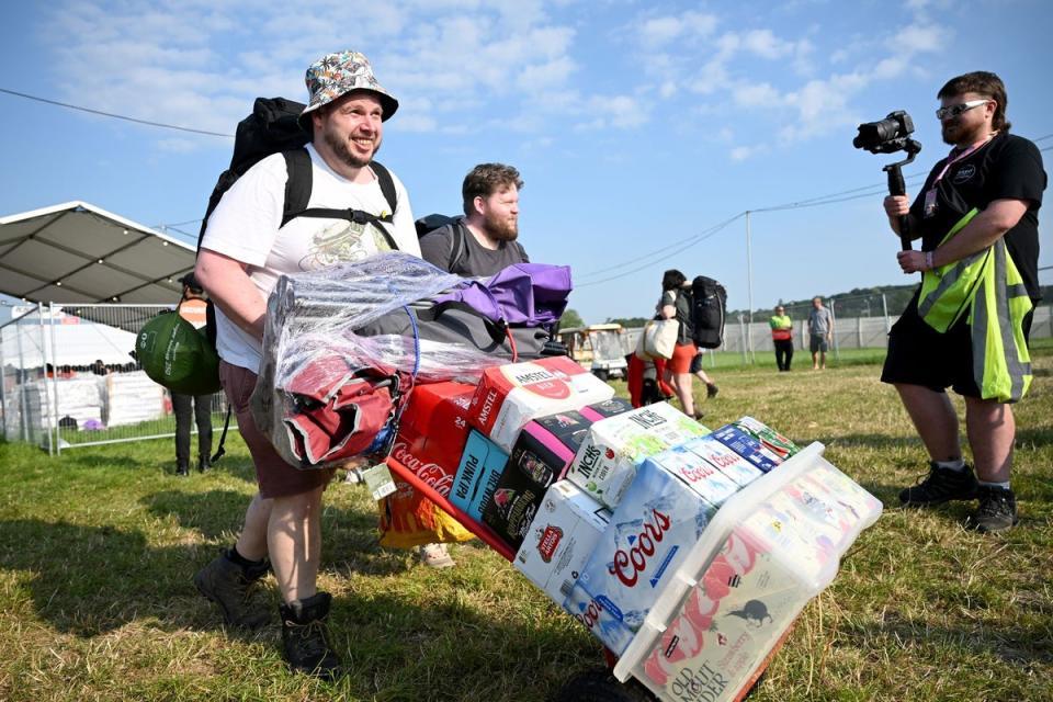 This reveller arriving at the festival on Wednesday with his personal stash of booze clearly got the memo (Getty Images)