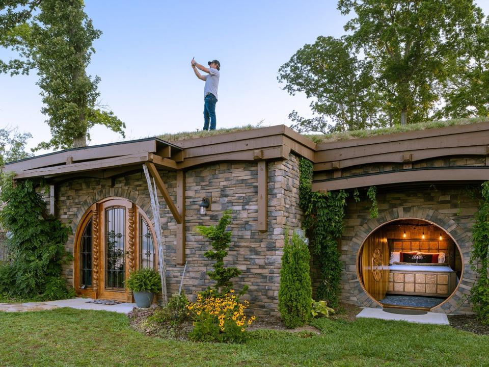 A man standing on top of the roof of Dragon's Knoll in North Carolina.