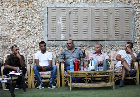 FILE PHOTO: Local residents sit with candidate Ramadan Dabash, a civil engineer from East Jerusalem who is running for a seat in city hall of Jerusalem in the upcoming municipal elections in Jerusalem September 4, 2018. REUTERS/Ammar Awad