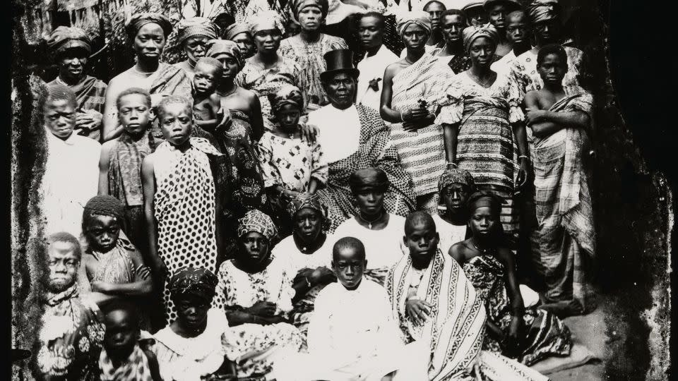 Pictured, a chief in a top hat surrounded by women and children. - Alex Agbaglo Acolatse/The Metropolitan Museum of Art