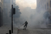 People clash with police during a protest against the political elites and the government after this week's deadly explosion at Beirut port which devastated large parts of the capital and killed more than 150 people, in Beirut, Lebanon, Saturday, Aug. 8, 2020. (AP Photo/Hassan Ammar)