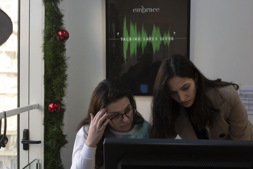 In this Monday, Dec. 23, 2019 photo, volunteers Farah, left, and Saha, wait for calls at Lebanon's Embrace, a mental health organization operating the national suicide prevention helpline in Beirut. Lebanon is entering its third month of protests, the economic pinch is hurting everyone, and the government is paralyzed. So people are resorting to what they've done in previous crises: They rely on each other, not the state. (AP Photo/Maya Alleruzzo)