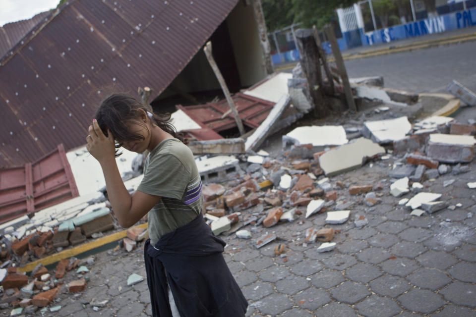 Una mujercamina frente a su casa destruida por el fuerte sismo que azotó la localidad de Nagarote, en el oeste de Nicaragua, el jueves 10 de abril de 2014. El temblor de magnitud 6,1 dañó decenas de viviendas y dejó un muerto y más de 200 heridos. El presidente Daniel Ortega decretó el alerta roja en todo el país tras las continuas réplicas que siguieron al sismo. (AP Foto/Esteban Félix)