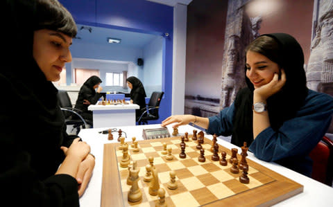 Iranian chess players Mitra Hejazipour (L) and Sara Khademalsharieh play at the Chess Federation in the capital Tehran on October 10, 2016.  - Credit: AFP