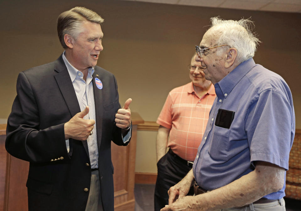 Republican Senate candidate Mark Harris, left, greets supporters Harvey Brown Sr, right, and Michael Cummings, back, at Harris' headquarters in Charlotte, N.C., Monday, May 5, 2014. The struggle for control of the Republican Party gets an early voter test in North Carolina, where GOP leaders Mitt Romney and Rand Paul push candidates competing against Democratic Sen. Kay Hagan in the November midterm elections. (AP Photo/Chuck Burton)