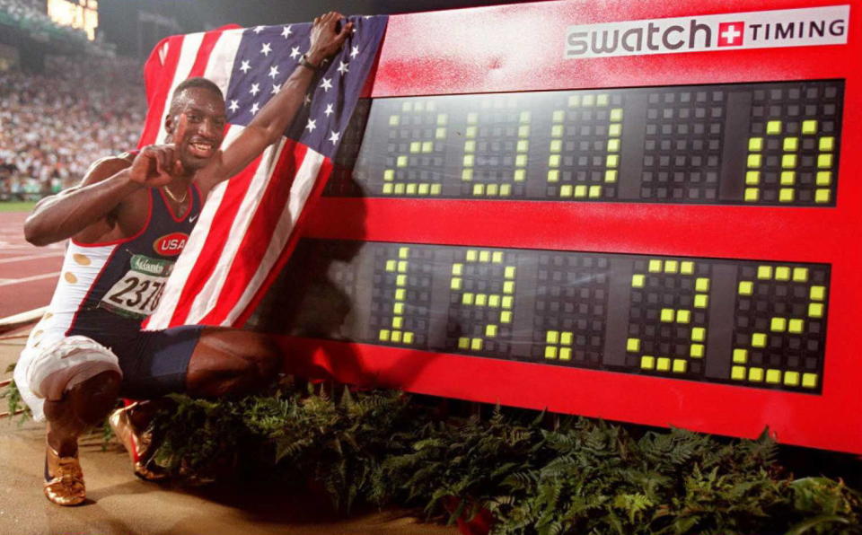 ATLANTA, GA - AUGUST 1:  Michael Johnson of the US (L)  poses for the press next to the clock after the men's Olympic 400m race at the Olympic Stadium in Atlanta, Georgia, 01 Aug. Johnson hurtled into history books in world record time as he completed an unprecedented Olympic double with the 400m and the 200m. Johnson clocked 19.32 sec to destroy Frankie Fredericks of Namibia (19.68) and Ato Boldon of Trinidad (19.80). (FOR EDITORIAL USE ONLY) AFP-IOPP/ Eric FEFERBERG  (Photo credit should read AFP-IOP/AFP via Getty Images)