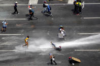 <p>A demonstrator is hit by a jet of water during a rally against Venezuela’s President Nicolas Maduro in Caracas, Venezuela, May 26, 2017. (Christian Veron/Reuters) </p>