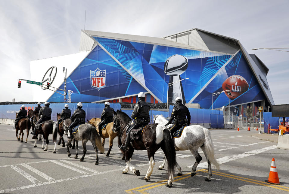 Police on horseback patrol past Mercedes-Benz Stadium ahead of Sunday's NFL Super Bowl 53 football game between the Los Angeles Rams and New England Patriots in Atlanta, Wednesday, Jan. 30, 2019. (AP Photo/David Goldman)