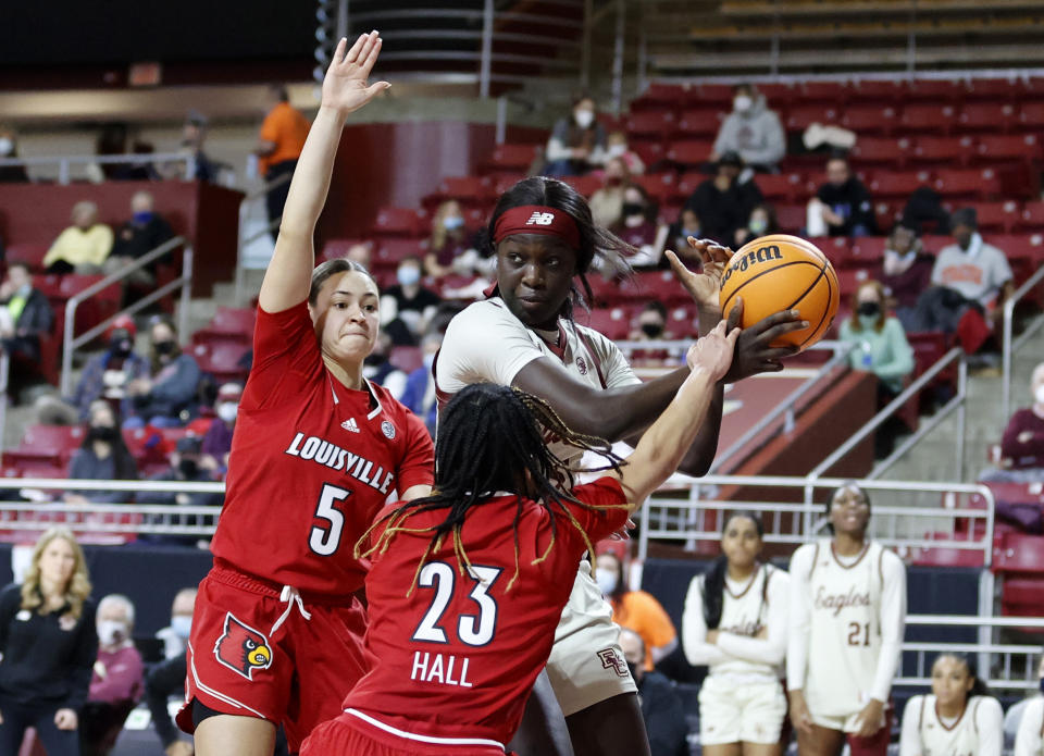 Boston College forward Maria Gakdeng (5) looks to pass under pressure from Louisville guard Mykasa Robinson (5) and Chelsie Hall (23) during the second half of an NCAA college basketball game, Sunday, Jan. 16, 2022, in Boston. (AP Photo/Mary Schwalm)