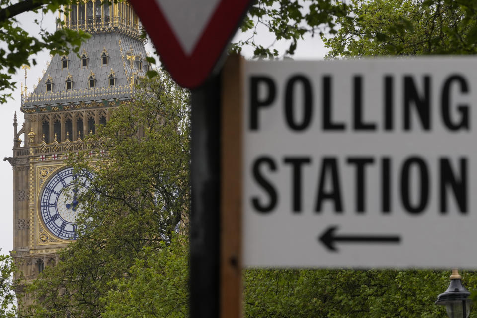 FILE - A sign points to where residents can cast their votes in London, Friday, May 3, 2024. U.K. voters are set to cast ballots in a national election on July 4, passing judgment on 14 years of Conservative rule. They are widely expected to do something they have not done since 2005 — elect a Labour Party government. (AP Photo/Kin Cheung, File)