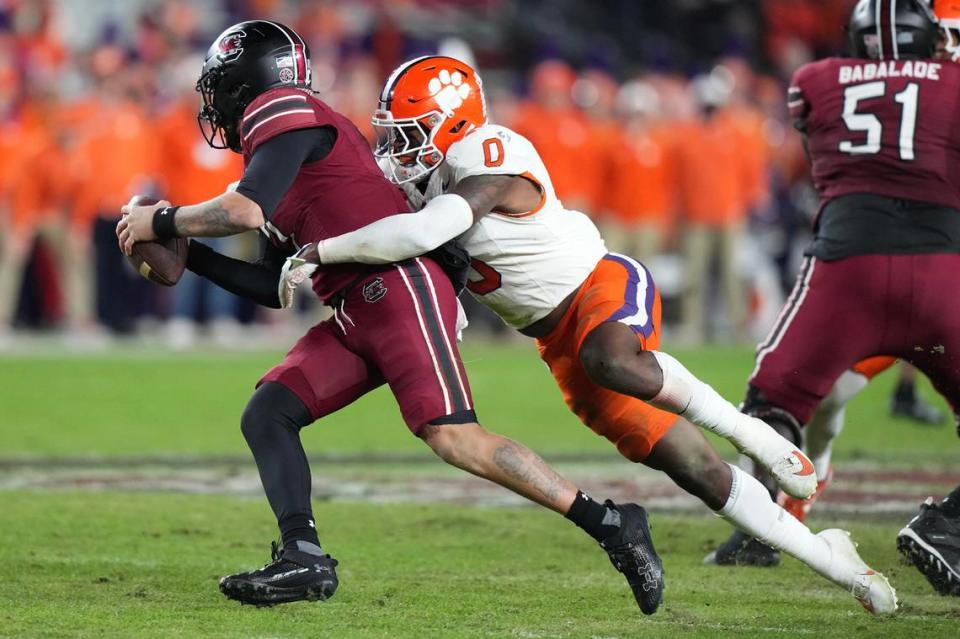 Nov 25, 2023; Columbia, South Carolina, USA; South Carolina Gamecocks quarterback Spencer Rattler (7) is sacked by Clemson Tigers linebacker Barrett Carter (0) in the first half at Williams-Brice Stadium. Mandatory Credit: David Yeazell-USA TODAY Sports