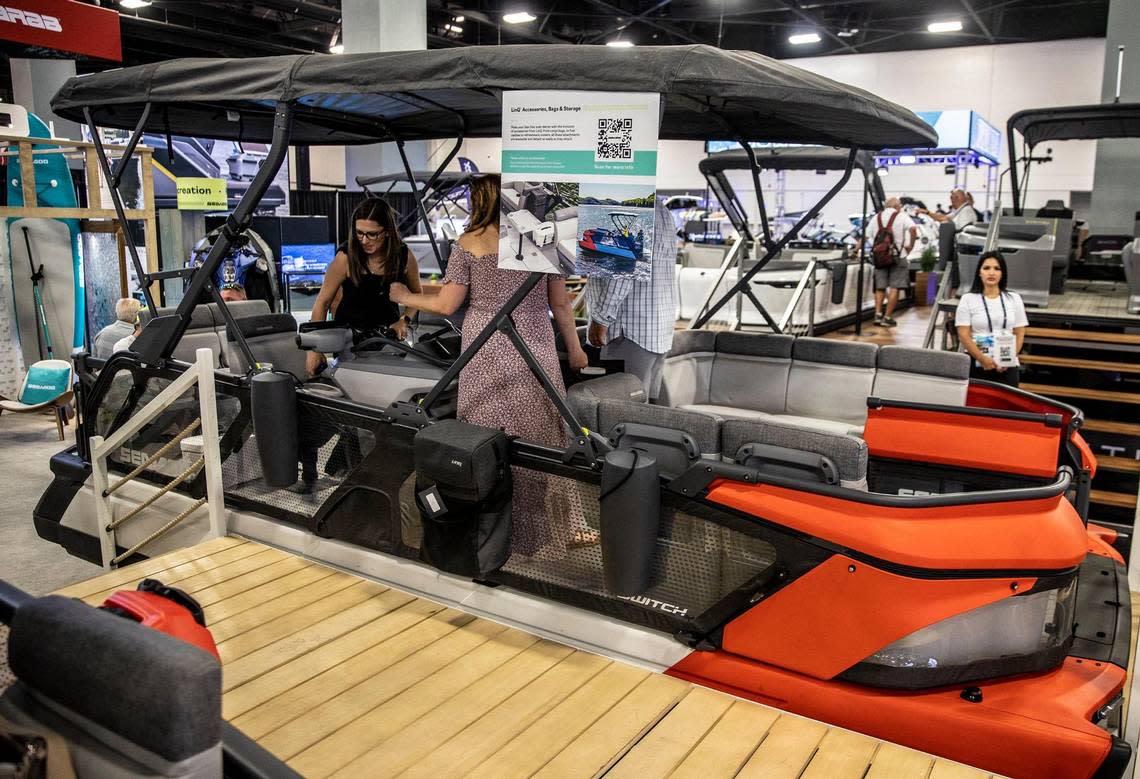 Boat enthusiasts check the Sea-Doo Switch Sport Pontoon vessel with a starting price of $27,399. It’s on display at Miami Beach Convention Center, during the 2023 Miami International Boat Show, on Friday Feb. 17, 2023.