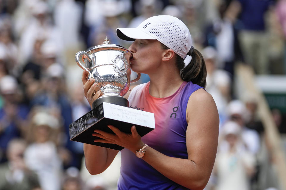 Iga Swiatek besa el trofeo tras vencer a Jasmine Paolini en la final del Abierto de Francia, el sábado 8 de junio de 2024. (AP Foto/Thibault Camus)