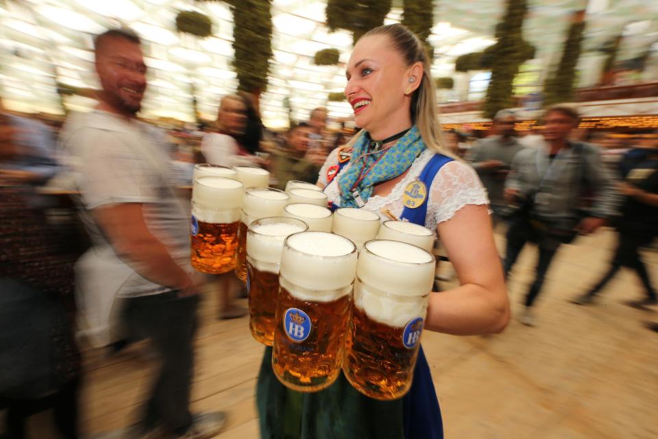 A waitress carries 1-liter mugs of beer during the opening weekend of Oktoberfest in 2019 in Munich, Germany.