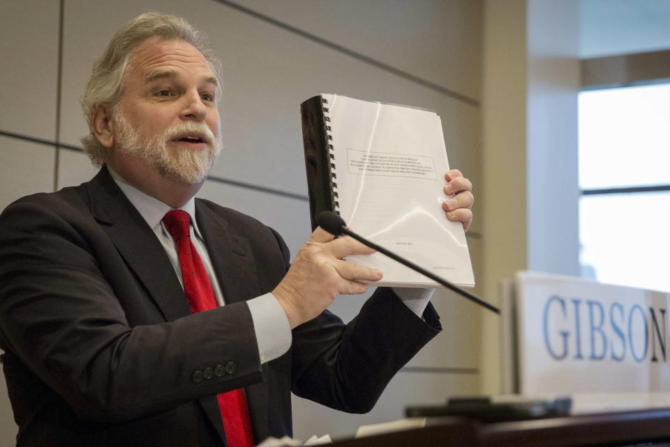 Attorney Randy Mastro holds up a copy of his report during a news conference Thursday, March 27, 2014, in New York. Mastro, with the law firm hired by New Jersey Gov. Chris Christie, said Thursday that the governor was not involved in a plot to create gridlock near a major bridge as part of a political retribution scheme. (AP Photo/Brendan McDermid, Pool)