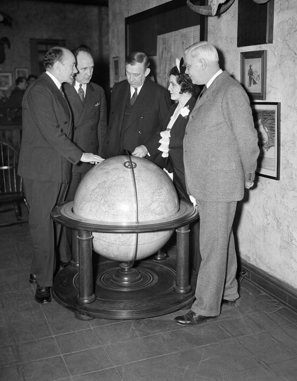 <p>Left to right: Sir George Hubert Wilkins, explorer and writer; Joseph Robinson, secretary of the Explorers’ Club; Walter Granger, president of club; Lady Grace Drummond Hay, writer; and Dr. H. J. Spinden, director of the Brooklyn Museum, study the route of the Zeppelin Hindenburg’s flight to America on a globe at the Explorers’ Club in New York on May 10, 1936. (AP Photo/John Lindsay) </p>