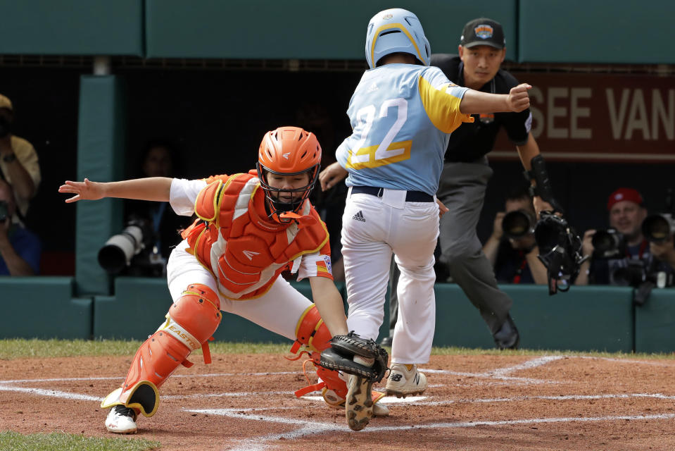 River Ridge, Louisiana, catcher Egan Prather, left, catches the leg of Wailuku, Hawaii's Bransyn Hong (22) for the out at home in the first inning of the United State Championship baseball game at the Little League World Series tournament in South Williamsport, Pa., Saturday, Aug. 24, 2019. (AP Photo/Gene J. Puskar)