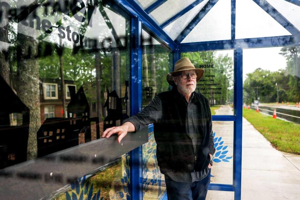 Tom Stanley stands in a covered shelter along CATS 211 bus stop on Tom Hunter Road and Canterwood Drive. The veteran artist teamed up with former Hidden Valley resident Unique Patton to work on designs for the shelter.