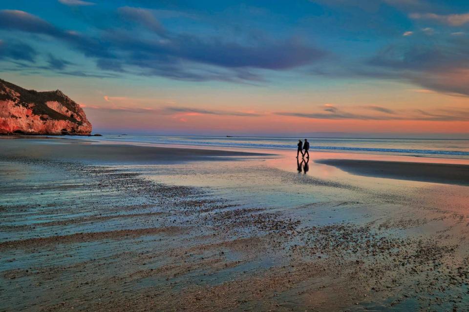 Two people walking at Sunset at Avila Beach