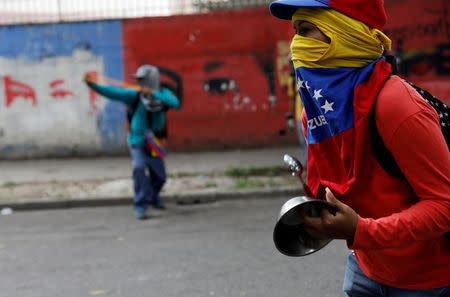 A demonstrator holds a pot as he attends the 'march of the empty pots' against Venezuelan President Nicolas Maduro's government in Caracas, Venezuela, June 3, 2017. REUTERS/Carlos Garcia Rawlins