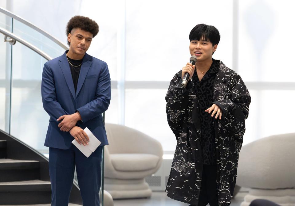 Vincent Yu, right, Adrian College assistant professor of fashion merchandising, addresses the audience Wednesday, March 27, 2024, during Adrian College's student-led fashion show, "Manifest the Runway." Also pictured is Cameron Wallace, left, one of two emcees for the evening's show.