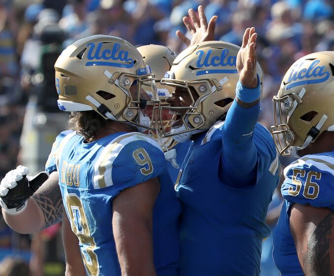 UCLA's Dorian Thompson-Robinson, middle right, and Jake Bobo (9) are fired up after Bobo scored a touchdown Oct. 8, 2022