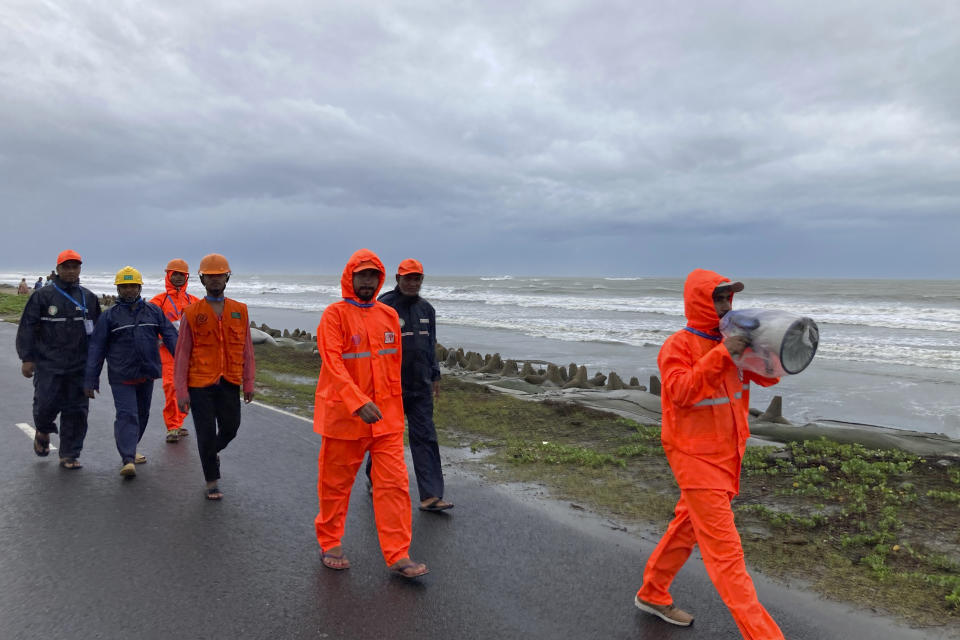 A government official, right, patrols with others near the coast and uses a megaphone asking people to seek shelter in Cox's Bazar district, Bangladesh, Sunday, May 14, 2023. Bangladesh and Myanmar are bracing as an extremely severe cyclone starts to hit their coastal areas, and authorities urged thousands of people in both countries to seek shelter. (AP Photo/Al-emrun Garjon)